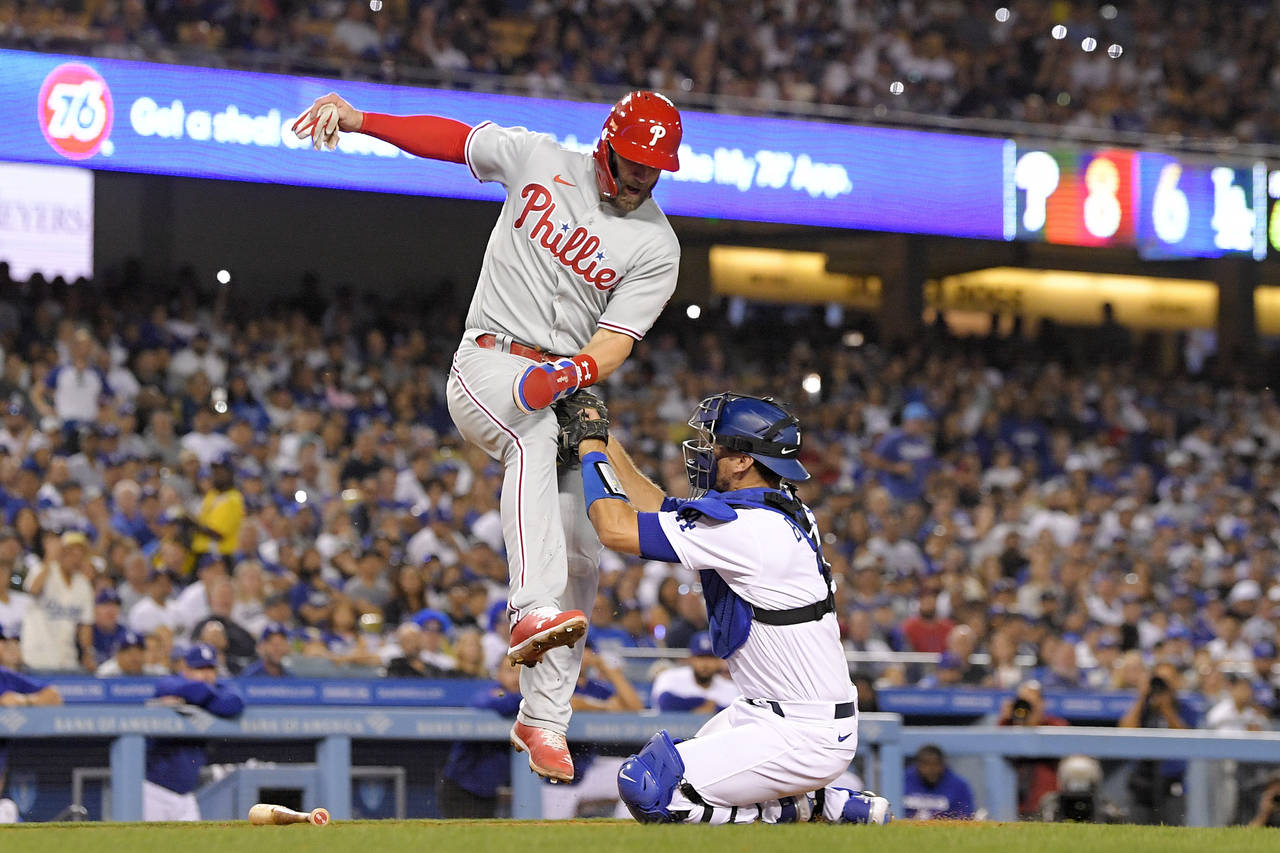 Philadelphia Phillies' Bryce Harper, left, is tagged out at home by Los Angeles Dodgers catcher Aus...
