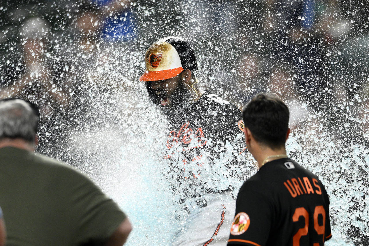 Baltimore Orioles' Rougned Odor, center, is doused after he hit a two-run walkoff home run during t...