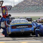 
              Ryan Blaney (12) and other racers make pit stops during the first stage of a NASCAR Cup Series auto race at Kansas Speedway in Kansas City, Kan., Sunday, May 15, 2022. (AP Photo/Colin E. Braley)
            