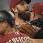 
              Arizona Diamondbacks' pitcher Madison Bumgarner, center, is restrained by bench coach Jeff Banister, right, while arguing with umpires after the first inning of a baseball game against the against the Miami Marlins, Wednesday, May 4, 2022, in Miami. (AP Photo/Jim Rassol)
            