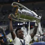 
              Real Madrid's Vinicius Junior holds the trophy after the Champions League final soccer match between Liverpool and Real Madrid at the Stade de France in Saint Denis near Paris, Saturday, May 28, 2022. (AP Photo/Frank Augstein)
            