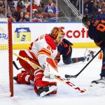 
              Calgary Flames goalie Jacob Markstrom, left, lets in a goal from Edmonton Oilers winger Evander Kane during the second period of an NHL hockey Stanley Cup second-round playoff series game in Edmonton, Alberta, Sunday, May 22, 2022. (Jeff McIntosh/The Canadian Press via AP)
            
