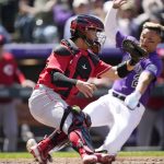 
              Cincinnati Reds catcher Mark Kolozsvary, left, fields a throw as Colorado Rockies' Yonathan Daza, right, scores on a double by Brendan Rodgers in the second inning of a baseball game Sunday, May 1, 2022, in Denver. (AP Photo/David Zalubowski)
            