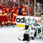 
              Dallas Stars goalie Jake Oettinger, second from right, is consoled by teammates as Calgary Flames celebrate following overtime NHL playoff hockey action in Calgary, Alberta, Sunday, May 15, 2022. (Jeff McIntosh/The Canadian Press via AP)
            