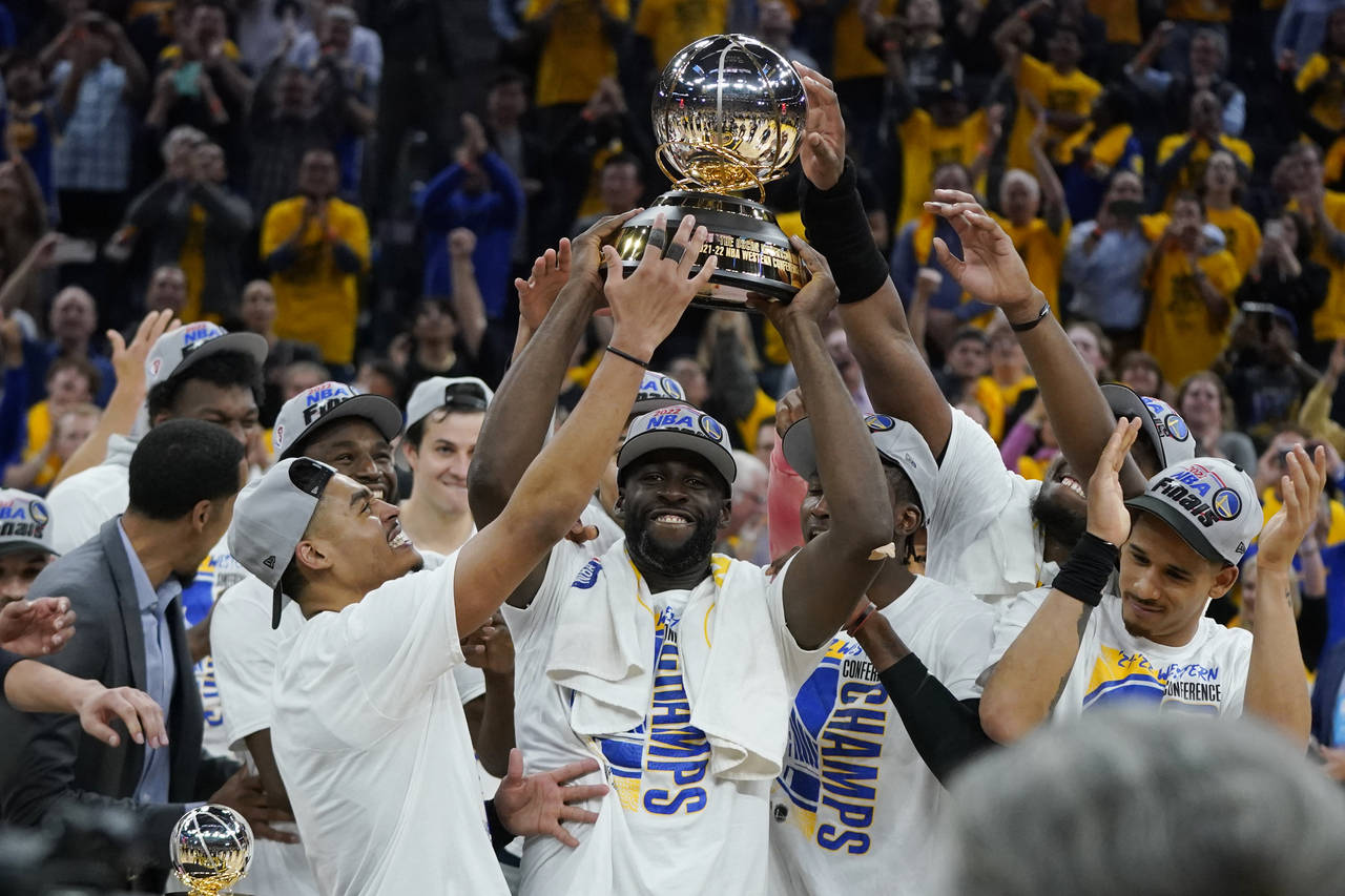 Golden State Warriors celebrate with the conference trophy after defeating the Dallas Mavericks in ...
