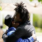 
              Buffalo Bills' Josh Thomas, right, embraces a person as he visits the scene of Saturday's shooting at a supermarket, in Buffalo, N.Y., Wednesday, May 18, 2022. (AP Photo/Matt Rourke)
            