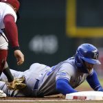 
              Kansas City Royals' Kyle Isbel, right, dives safely back to first base as Arizona Diamondbacks first baseman Christian Walker, left, applies a late tag during the first inning of a baseball game Monday, May 23, 2022, in Phoenix. (AP Photo/Ross D. Franklin)
            
