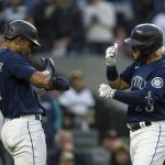 
              Seattle Mariners' Eugenio Suarez, right, celebrates with teammate Julio Rodriguez after hitting a two-run home run off Oakland Athletics starting pitcher Zach Logue during the fifth inning of a baseball game, Monday, May 23, 2022, in Seattle. Rodriguez also scored on the hit. (AP Photo/Stephen Brashear)
            