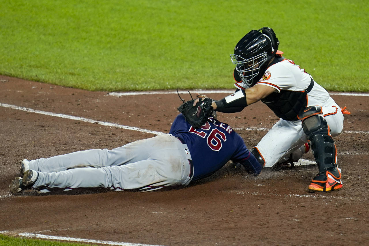 Baltimore Orioles catcher Robinson Chirinos, right, tags out Minnesota Twins' Max Kepler trying to ...