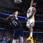 
              Golden State Warriors forward Andrew Wiggins (22) dunks the ball over Dallas Mavericks guard Luka Doncic (77) during the second half of Game 3 of the NBA basketball playoffs Western Conference finals, Sunday, May 22, 2022, in Dallas. (AP Photo/Tony Gutierrez)
            