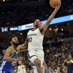 
              Memphis Grizzlies guard De'Anthony Melton (0) shoots ahead of Golden State Warriors forward Andrew Wiggins in the first half during Game 1 of a second-round NBA basketball playoff series Sunday, May 1, 2022, in Memphis, Tenn. (AP Photo/Brandon Dill)
            