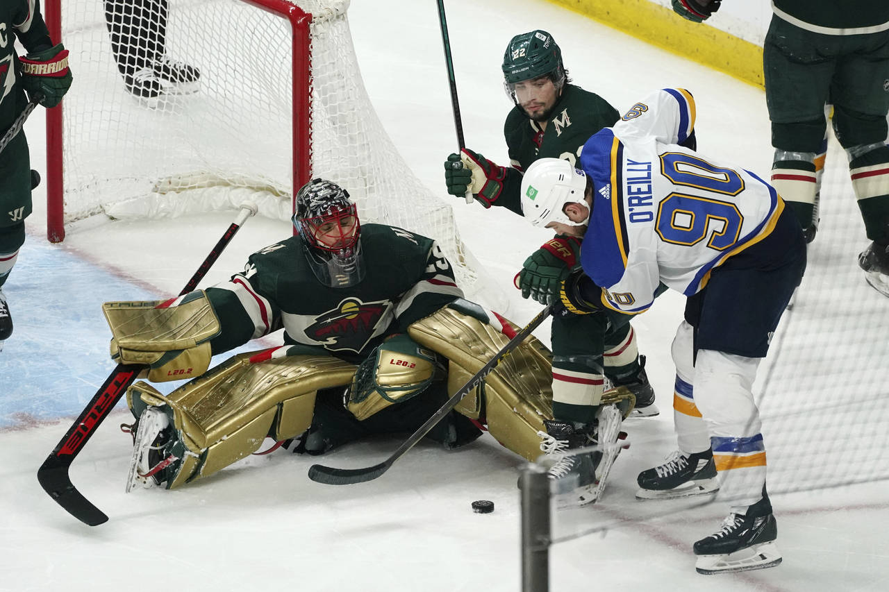 St. Louis Blues' Ryan O'Reilly (90) works against Minnesota Wild's Kevin Fiala (22) for the puck in...