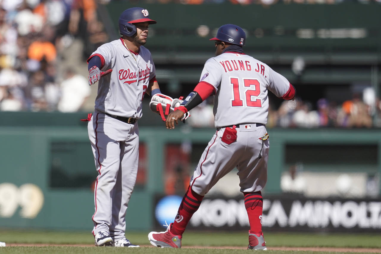 Washington Nationals' Yadiel Hernandez, left, is congratulated by first base coach Eric Young Jr. (...