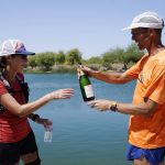 
              Jacky Hunt-Broersma, left, gets a delivery of champagne from her husband, Edwin Broersma, after Jacky finished her 102nd marathon in 102 days, this one at Veterans Oasis Park, Thursday, April 28, 2022, in Chandler, Ariz. (AP Photo/Ross D. Franklin)
            
