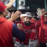 
              Los Angeles Angels' Anthony Rendon, center, celebrates in the dugout after hitting a two-run home run during the third inning of the team's baseball game against the Texas Rangers, Tuesday, May 17, 2022, in Arlington, Texas. (AP Photo/Tony Gutierrez)
            