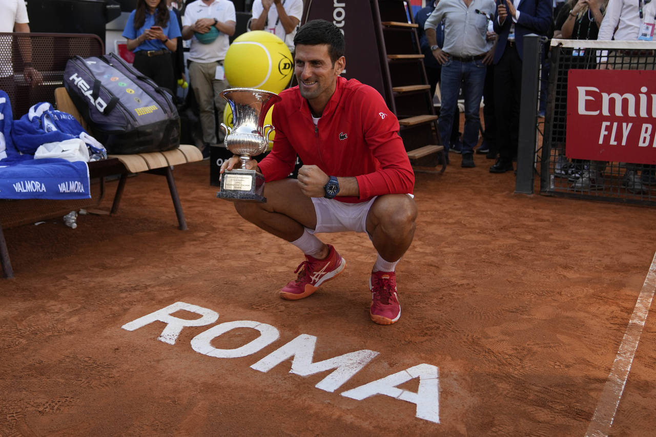 Serbia's Novak Djokovic poses for photographers with trophy after winning his final match against G...