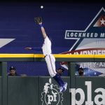
              Texas Rangers center fielder Eli White leaps to the top of the wall to catch a flyout by Tampa Bay Rays' Ji-Man Choi in the first inning of a baseball game, Monday, May 30, 2022, in Arlington, Texas. (AP Photo/Tony Gutierrez)
            