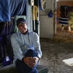 
              Tim Yakteen smiles in his horse barn at Santa Anita Park on Monday, April 25, 2022, in Arcadia, Calif. He will saddle two horses - Messier and Taiba, both formerly trained by Bob Baffert - for the Kentucky Derby. Baffert is serving a 90-day suspension from horse racing. (AP Photo/Ashley Landis)
            