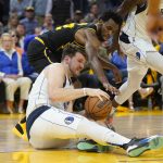 
              Dallas Mavericks guard Luka Doncic, bottom, holds onto the ball under Golden State Warriors forward Andrew Wiggins during the second half of Game 5 of the NBA basketball playoffs Western Conference finals in San Francisco, Thursday, May 26, 2022. (AP Photo/Jeff Chiu)
            