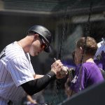 
              Colorado Rockies catcher Brian Serven, left, signs an autograph for a fan before making his Major League debut in a baseball game against the San Francisco Giants, Wednesday, May 18, 2022, in Denver. (AP Photo/David Zalubowski)
            