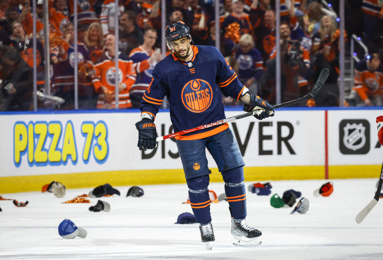 Edmonton Oilers winger Evander Kane skates amongst hats thrown onto the ice after his hat-trick dur...