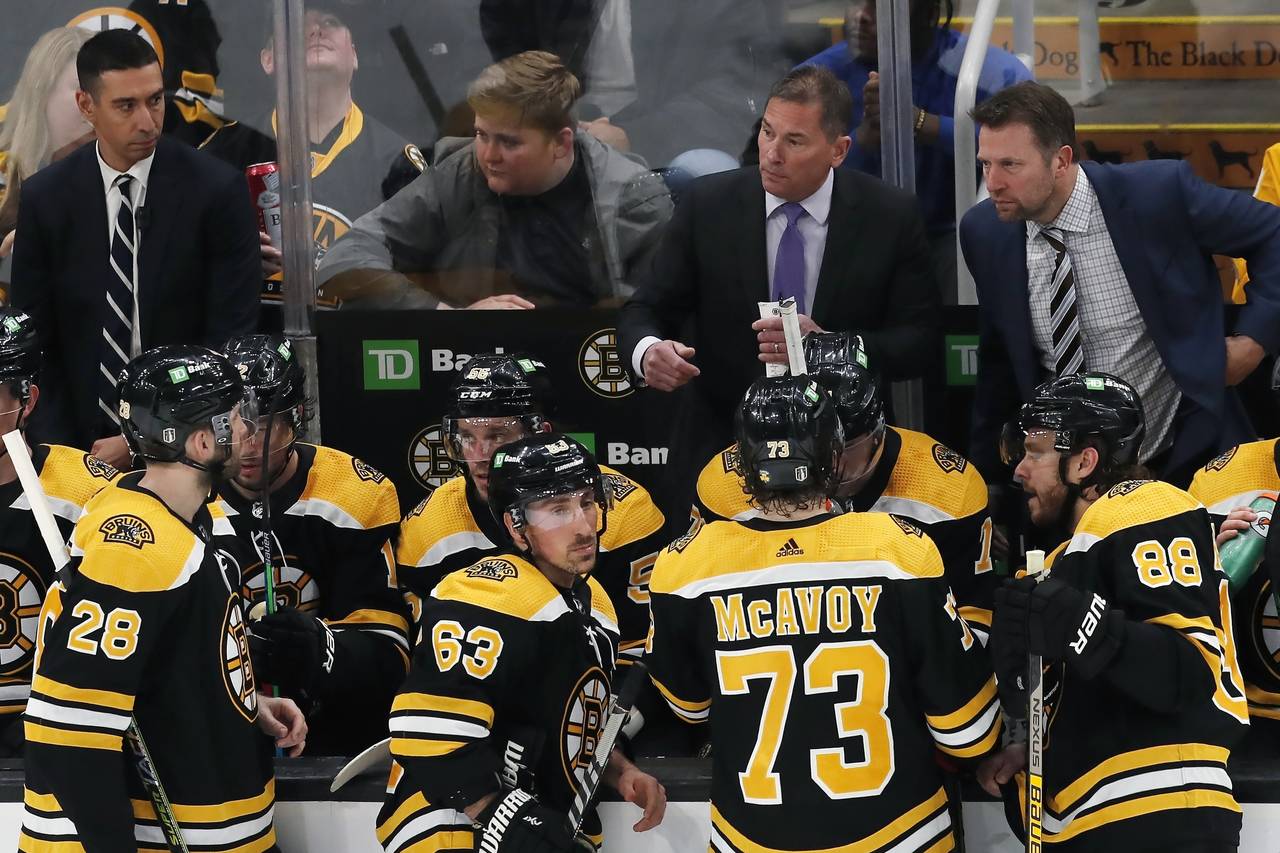 Boston Bruins head coach Bruce Cassidy, top second from right, talks to his team during a timeout i...