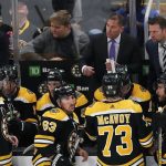 
              Boston Bruins head coach Bruce Cassidy, top second from right, talks to his team during a timeout in the third period of Game 3 of an NHL hockey Stanley Cup first-round playoff series against the Carolina Hurricanes, Friday, May 6, 2022, in Boston. (AP Photo/Michael Dwyer)
            
