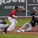 
              Chicago White Sox's Tim Anderson (7) slides into third base ahead of the throw to Boston Red Sox third baseman Rafael Devers on a single by Jose Abreu, as third base coach Joe McEwing (47) watches during the first inning of a baseball game at Fenway Park, Friday, May 6, 2022, in Boston. (AP Photo/Mary Schwalm)
            