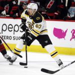 
              Boston Bruins' Brad Marchand (63) tries to move the puck around Carolina Hurricanes' Jesper Fast (71) during the third period of Game 7 of an NHL hockey Stanley Cup first-round playoff series in Raleigh, N.C., Saturday, May 14, 2022. (AP Photo/Karl B DeBlaker)
            