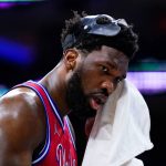 
              Philadelphia 76ers' Joel Embiid wipes his face during the first half of Game 4 of an NBA basketball second-round playoff series against the Miami Heat, Sunday, May 8, 2022, in Philadelphia. (AP Photo/Matt Slocum)
            
