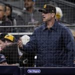 
              Michigan head football coach Jim Harbaugh reacts as he watches the San Diego Padres play against the Chicago Cubs in a baseball game Monday, May 9, 2022, in San Diego. (AP Photo/Gregory Bull)
            