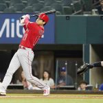 
              Los Angeles Angels Shohei Ohtani, of Japan, hits a double in front of Texas Rangers catcher Jonah Heim (28) during the first inning of a baseball game in Arlington, Texas, Monday, May 16, 2022. (AP Photo/LM Otero)
            