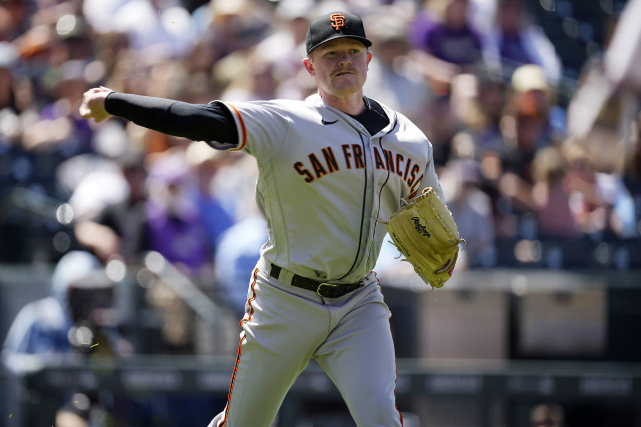 San Francisco Giants starting pitcher Logan Webb throws to first base to force out Colorado Rockies...