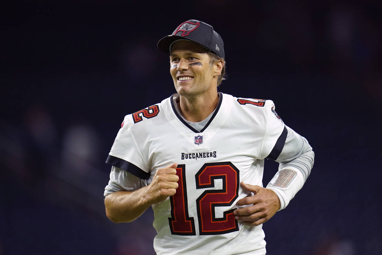 FILE -Tampa Bay Buccaneers quarterback Tom Brady (12) smiles as he runs off the field after an NFL ...