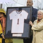 
              FILE - Before the start of a women's lacrosse game between Virginia and Penn State, University of Virginia athletic director Craig Littlepage presents Yeardley Love's sister Lexie, left, and mother, Sharon, with a jersey with Yeardley's number Sunday, March 6, 2011, in Charlottesville, Va. Nearly 12 years after Love was found dead, George Huguely, convicted of second-degree murder in her killing is headed back to court for a civil trial. Jury selection is expected in Charlottesville Circuit Court Monday, April 25, 2022 in a trial that will seek to hold George Huguely V liable in the death of Love.  (Sabrina Schaeffer/The Daily Progress via AP, File)
            