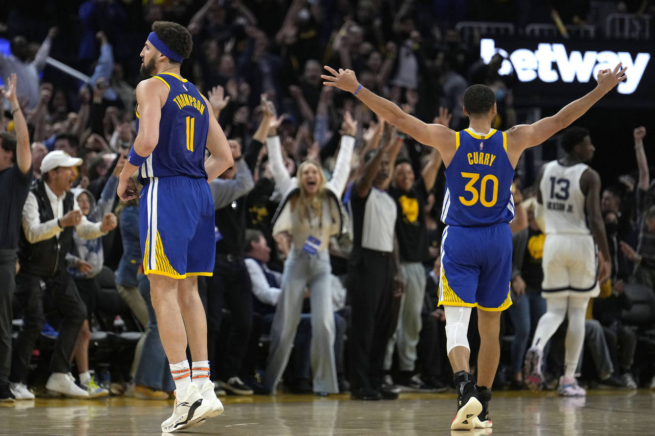 Golden State Warriors guard Stephen Curry (30) celebrates a 3-pointer by Klay Thompson, left, again...
