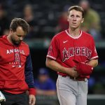 
              A member of the Los Angeles Angels staff walks off the field with first baseman Matt Duffy, who left th baseball game with an unknown injury following a collision with Texas Rangers' Adolis Garcia during the eighth inning Tuesday, May 17, 2022, in Arlington, Texas. (AP Photo/Tony Gutierrez)
            