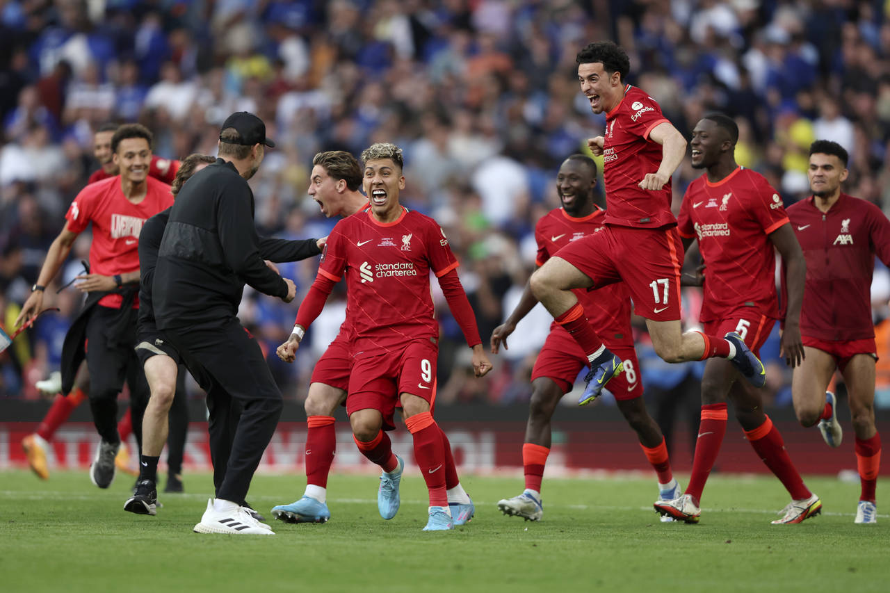 Liverpool players runs towards Liverpool's manager Jurgen Klopp, left, celebrating after scoring th...