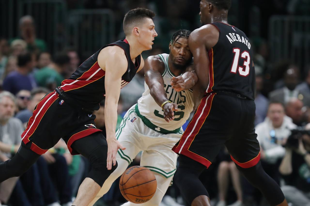 Miami Heat's Bam Adebayo (13) screens Boston Celtics' Marcus Smart (36) as Tyler Herro, left, drive...
