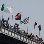 
              Fans look on as the flags blow in the wind during practice for the Indianapolis 500 auto race at Indianapolis Motor Speedway, Friday, May 20, 2022, in Indianapolis. (AP Photo/Darron Cummings)
            
