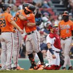 
              Baltimore Orioles' Rougned Odor, third from left, celebrates his three-run home run that also drove in Anthony Santander (25) and Ramon Urias (29), as Boston Red Sox's Christian Vazquez, second from right, kneels at home plate during the third inning of the second game of a baseball doubleheader, Saturday, May 28, 2022, in Boston. (AP Photo/Michael Dwyer)
            