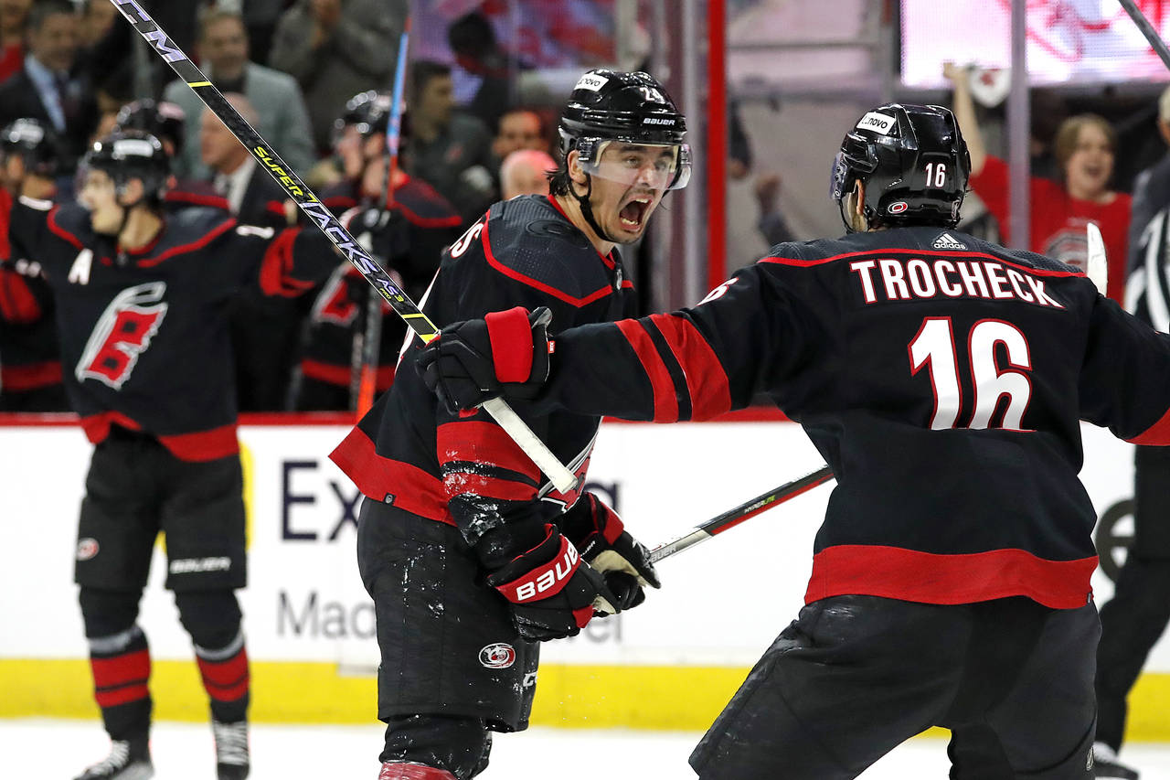Carolina Hurricanes' Seth Jarvis, center, celebrates his goal with teammate Vincent Trocheck (16) d...