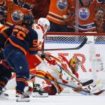 
              Calgary Flames goalie Jacob Markstrom, right, dives for the puck as Edmonton Oilers winger Kailer Yamamoto races for it  during the first period of an NHL hockey Stanley Cup second-round playoff series game in Edmonton, Alberta, Sunday, May 22, 2022. (Jeff McIntosh/The Canadian Press via AP)
            