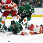 
              Calgary Flames center Elias Lindholm (28), Dallas Stars defenseman Joel Hanley (44) and Flames center Blake Coleman (20) compete for the puck during the second period of Game 3 of an NHL hockey Stanley Cup first-round playoff series Saturday, May 7, 2022, in Dallas. (AP Photo/Tony Gutierrez)
            