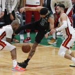 
              Boston Celtics' Jayson Tatum (0) competes against Miami Heat's Kyle Lowry (7) and Max Strus for the ball during the second half of Game 6 of the NBA basketball playoffs Eastern Conference finals Friday, May 27, 2022, in Boston. (AP Photo/Michael Dwyer)
            