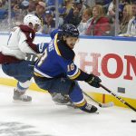 
              St. Louis Blues' Robert Thomas (18) and Colorado Avalanche's Cale Makar (8) chase after a loose puck along the boards during the second period in Game 3 of an NHL hockey Stanley Cup second-round playoff series Saturday, May 21, 2022, in St. Louis. (AP Photo/Jeff Roberson)
            