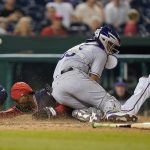 
              Washington Nationals' Dee Strange-Gordon slides past Colorado Rockies catcher Elias Diaz as he scores on a bunt single that was hit by Victor Robles in the eighth inning of a baseball game, Thursday, May 26, 2022, in Washington. Washington won 7-3. (AP Photo/Patrick Semansky)
            