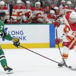 
              Dallas Stars defenseman John Klingberg (3) deflects a shot by Calgary Flames left wing Johnny Gaudreau (13) during the second period of Game 3 of an NHL hockey Stanley Cup first-round playoff series Saturday, May 7, 2022, in Dallas. (AP Photo/Tony Gutierrez)
            