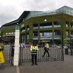 
              FILE - Security guards are shown at the gate in front of Centre Court at the All England Lawn Tennis Club, after the 2020 tennis championships were canceled due to the coronavirus, in Wimbledon, London, Monday, June 29, 2020. The ATP men’s professional tennis tour will not award ranking points for Wimbledon this year because of the All England Club’s ban on players from Russia and Belarus over the invasion of Ukraine. The ATP announced its decision Friday night, May 20, 2022, two days before the start of the French Open — and a little more than a month before play begins at Wimbledon on June 27. It is a highly unusual and significant rebuke of the oldest Grand Slam tournament.  (AP Photo/Kirsty Wigglesworth, File)
            