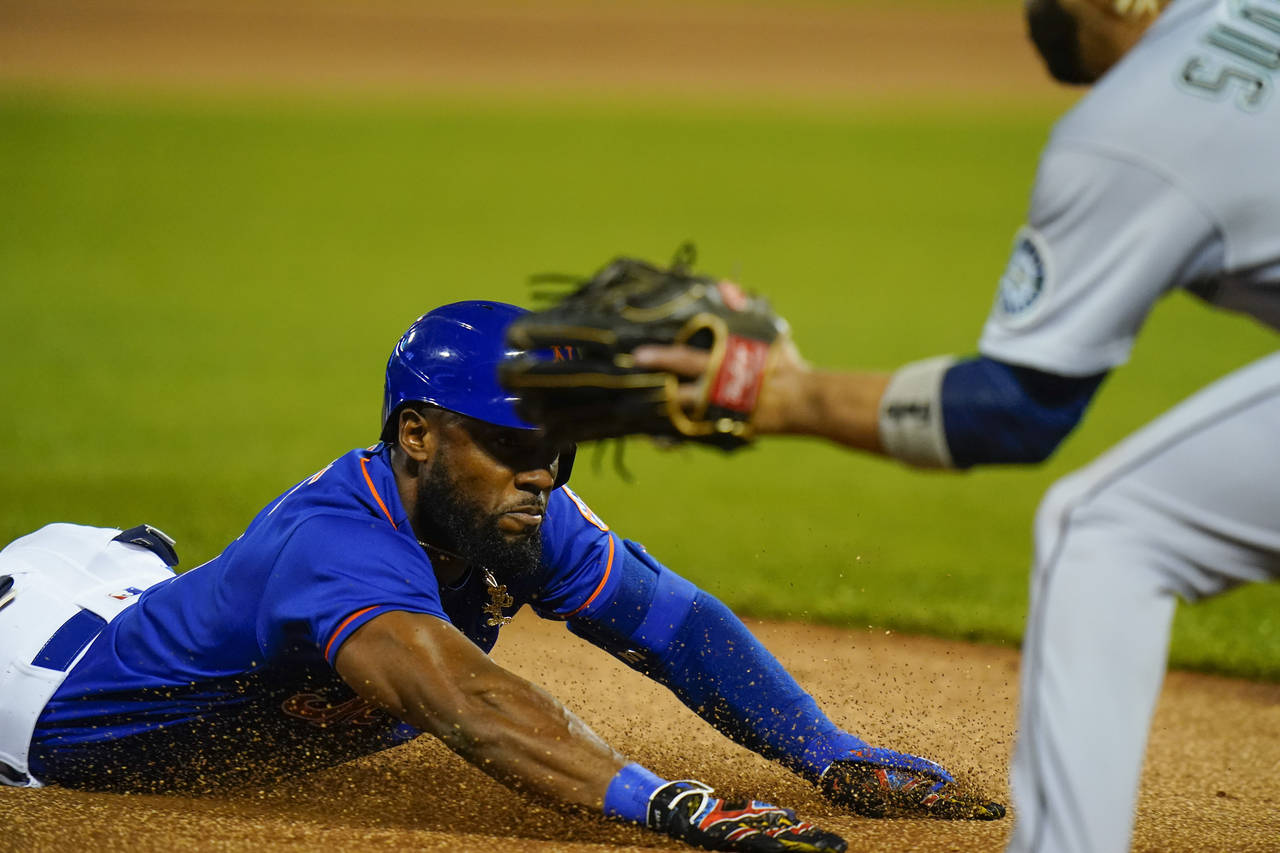 New York Mets' Starling Marte slides to third base during the first inning of a baseball game again...